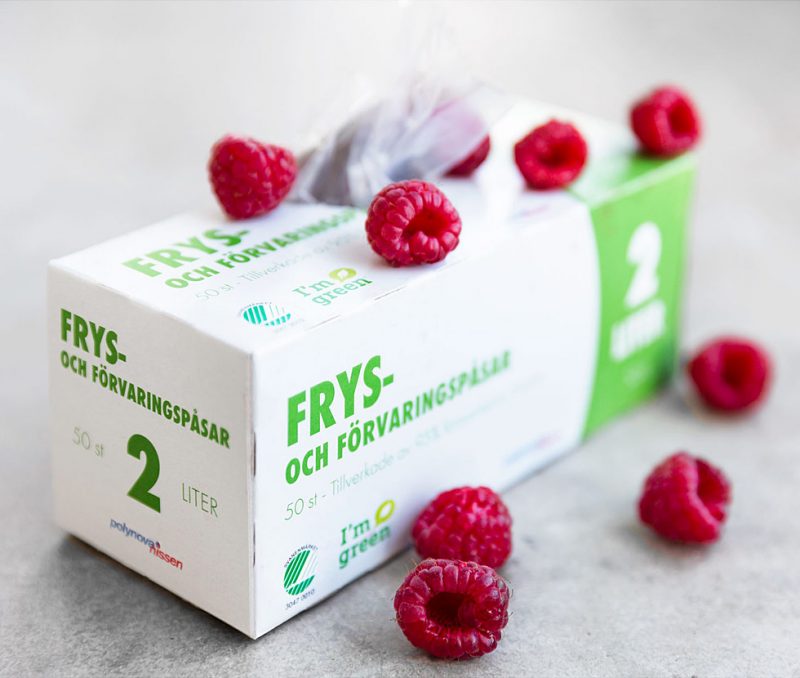 förpackning för fryspåsar med hallon utströdda kring sig